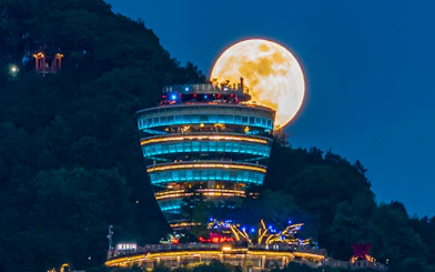 Chongqing Nanshan OneTree night view with illuminated tower and full moon.