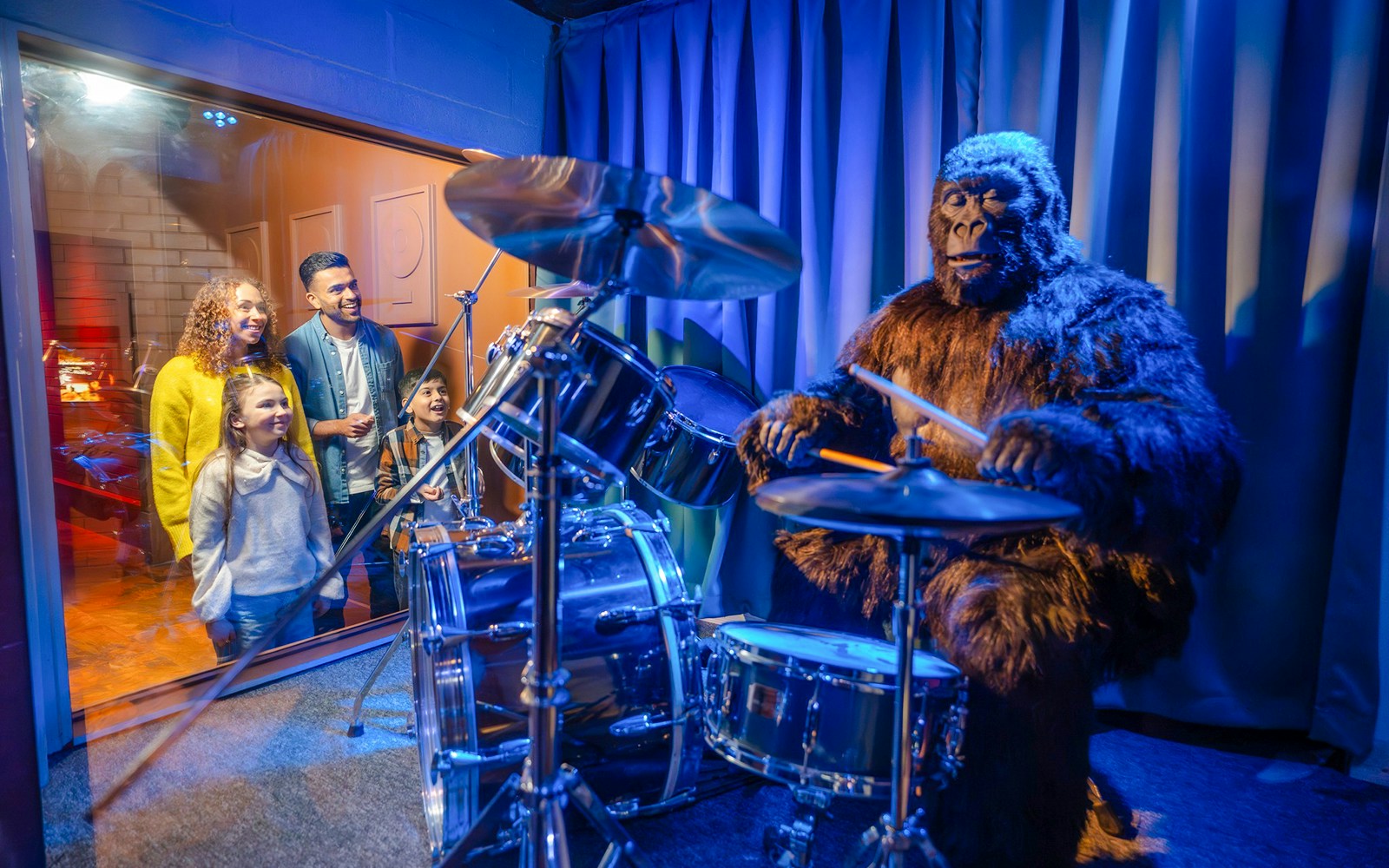 Visitors watching a gorilla playing drums at Cadbury World.