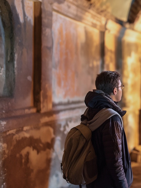 Visitors exploring ancient catacombs in Rome, part of the Jubilee Gold Pass tour.