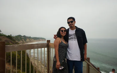 Couple on a coastal overlook with cliffs and ocean view, Santa Monica to Malibu tour.