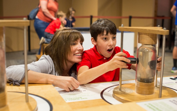 Child exploring interactive exhibit at San Diego science museum.