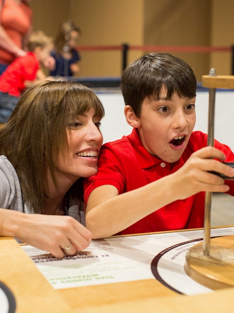 Child exploring interactive exhibit at San Diego science museum.