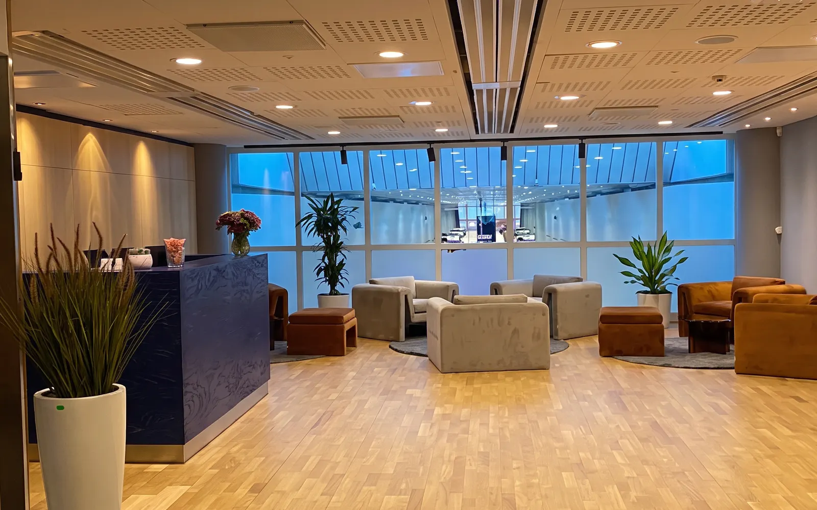 Pearl Lounge seating area with plants and reception at Stockholm Arlanda Airport Terminal 2.