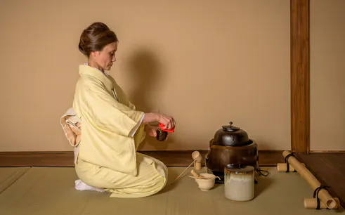 Person in kimono performing tea ceremony in Shinjuku.