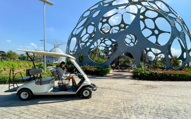 Golf cart near modern sculpture at Flower Land Pattaya.