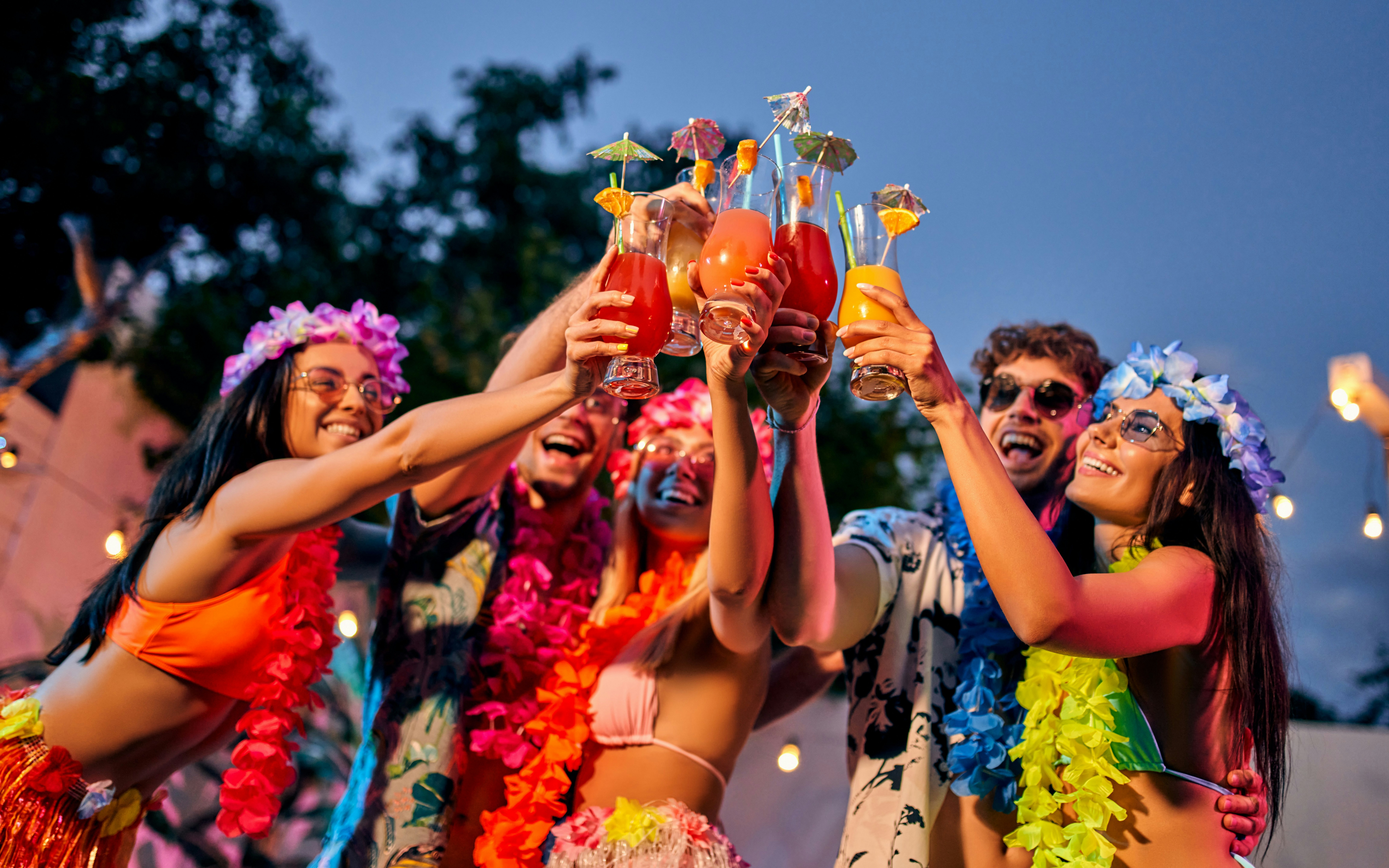 Friends celebrating with tropical drinks at a party in Hawaii.