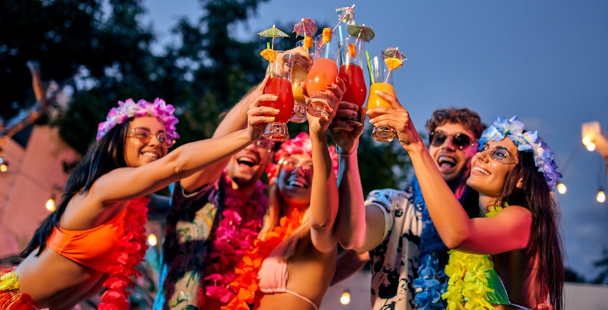 Friends celebrating with tropical drinks at a party in Hawaii.