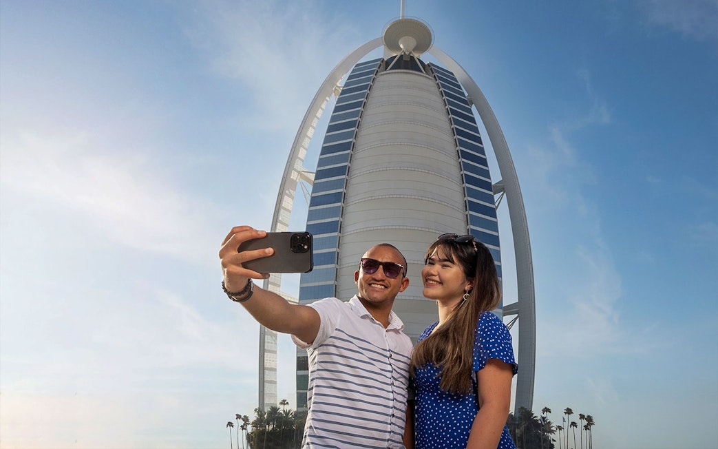 Tourists taking a selfie in front of Burj Al Arab during Inside Burj Al Arab Tour in Dubai.