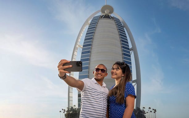 Tourists taking a selfie in front of Burj Al Arab during Inside Burj Al Arab Tour in Dubai.