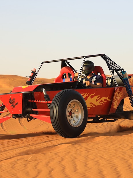 Dune buggy driving through Arabian desert during premium safari experience.