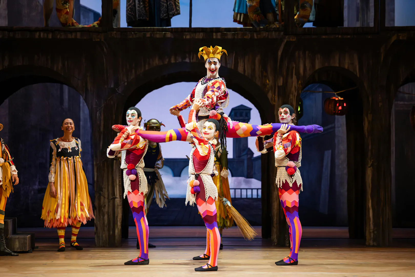Australian Ballet performers in colorful costumes during Romeo and Juliet scene.