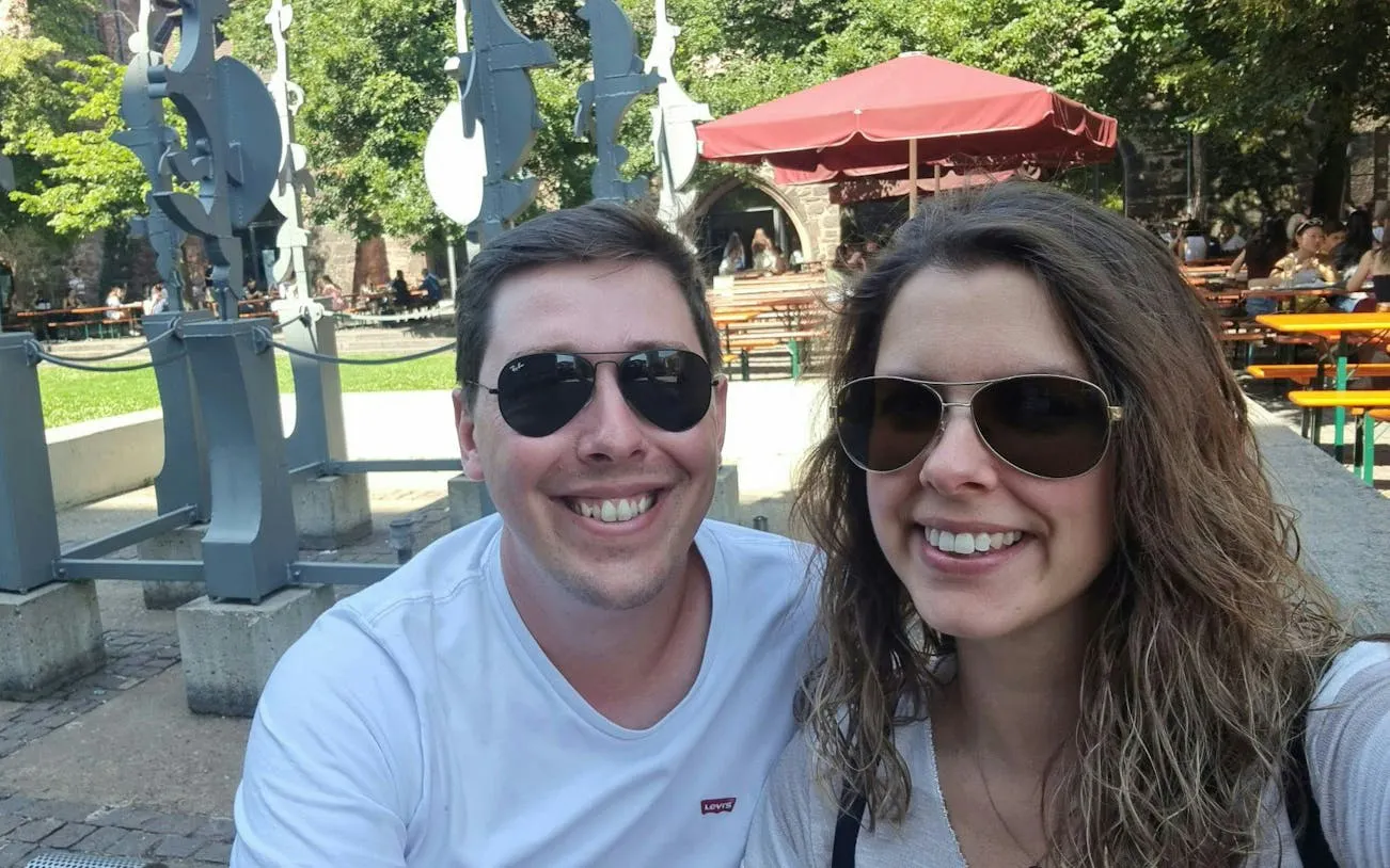 Couple enjoying outdoor seating near sculptures in Heidelberg during self-guided city exploration game.