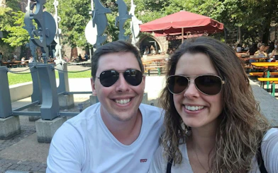 Couple enjoying outdoor seating near sculptures in Heidelberg during self-guided city exploration game.