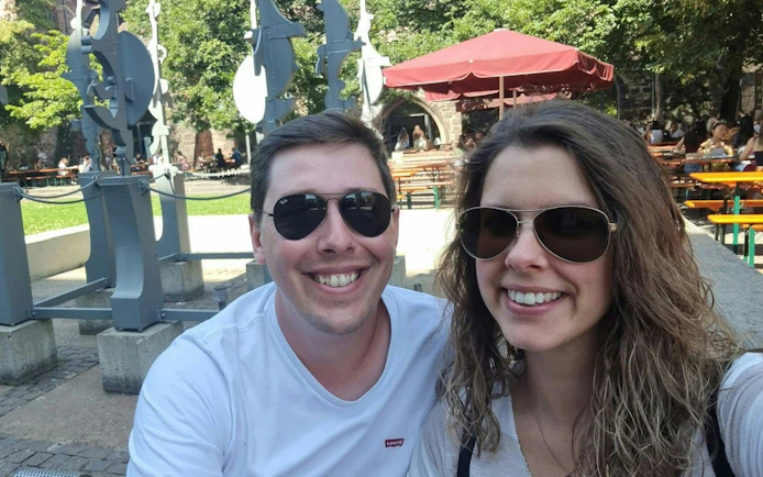 Couple enjoying outdoor seating near sculptures in Heidelberg during self-guided city exploration game.