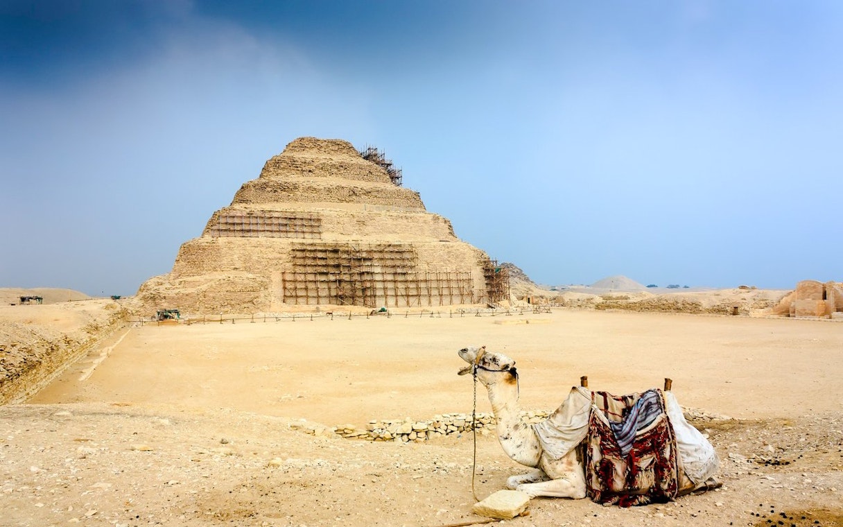 Step Pyramid of Djoser at Giza Complex with a resting camel in the foreground.