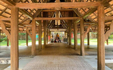 Traditional wooden pavilion with Buddha statue in Chiang Mai temple.