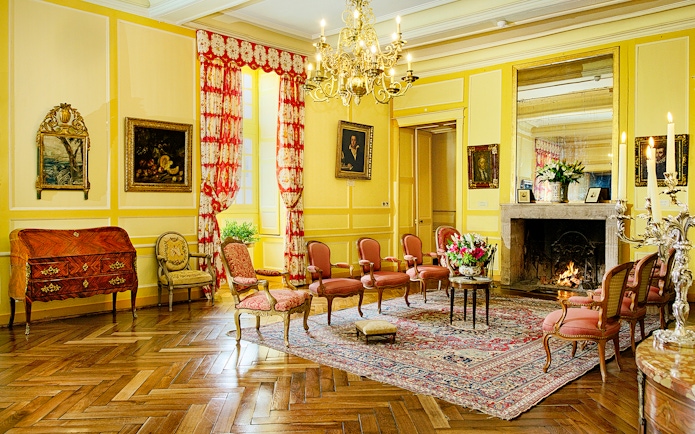 Chateau de Villandry sitting room with ornate chairs, fireplace, and chandelier.