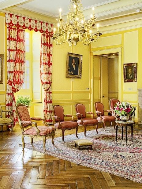 Chateau de Villandry sitting room with ornate chairs, fireplace, and chandelier.