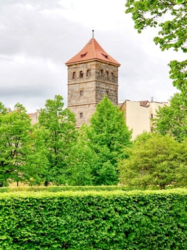 New Mill Water Tower in Prague surrounded by lush green trees.