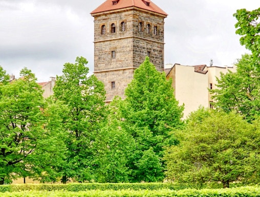 New Mill Water Tower in Prague surrounded by lush green trees.