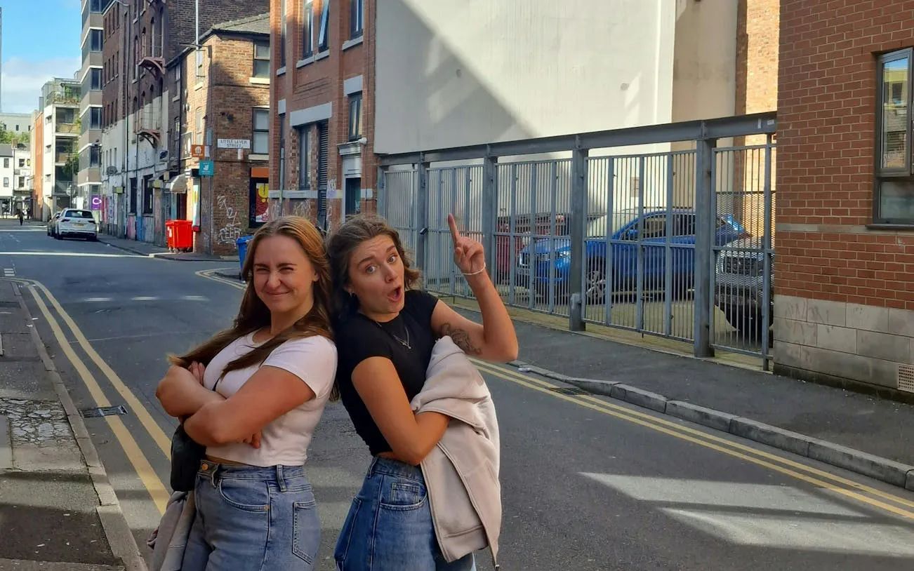Two people enjoying a self-guided city exploration game in Manchester street.