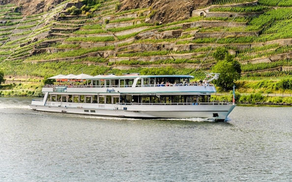 River cruise boat on the Moselle with vineyard terraces in the background near Koblenz.
