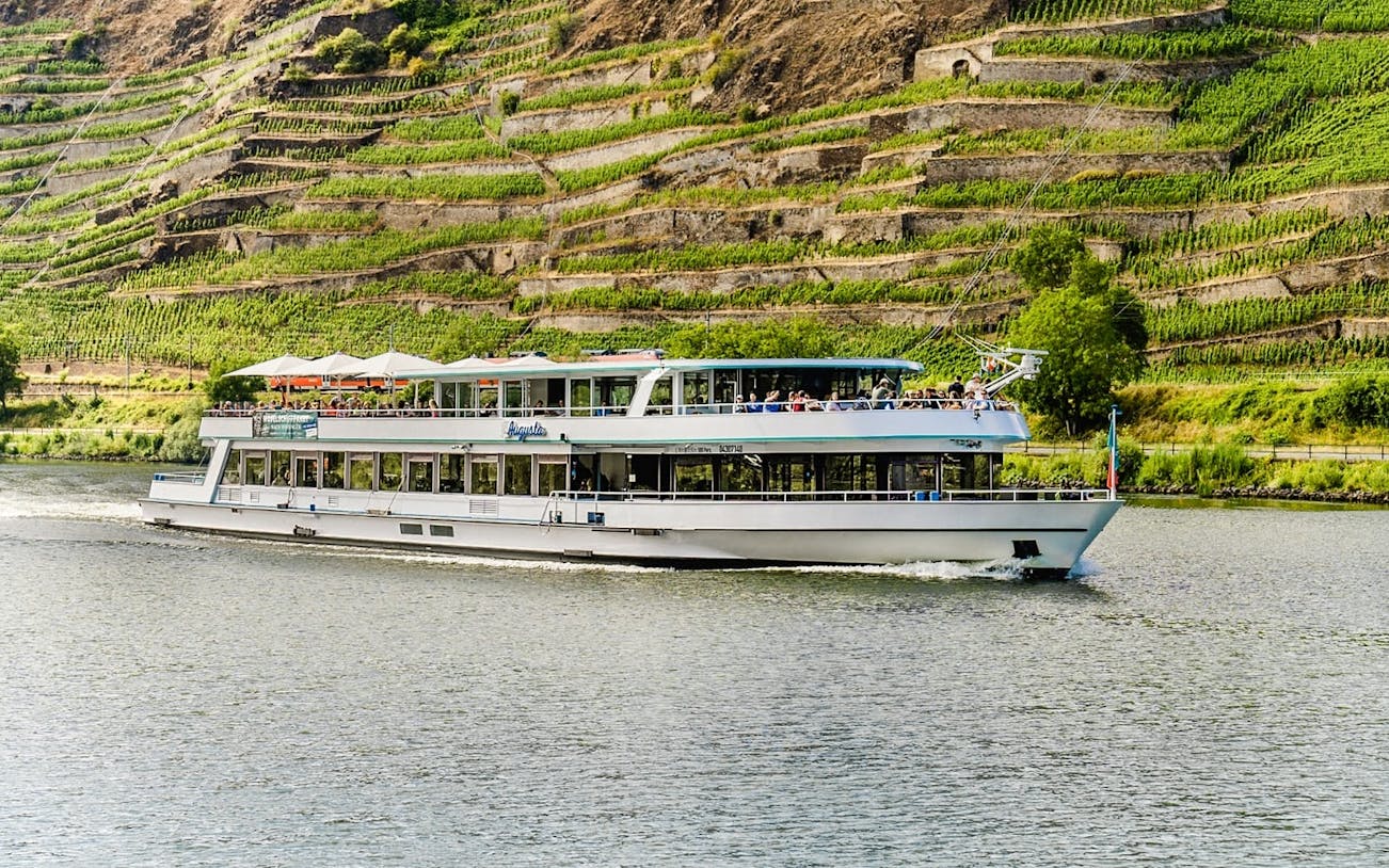 River cruise boat on the Moselle with vineyard terraces in the background near Koblenz.