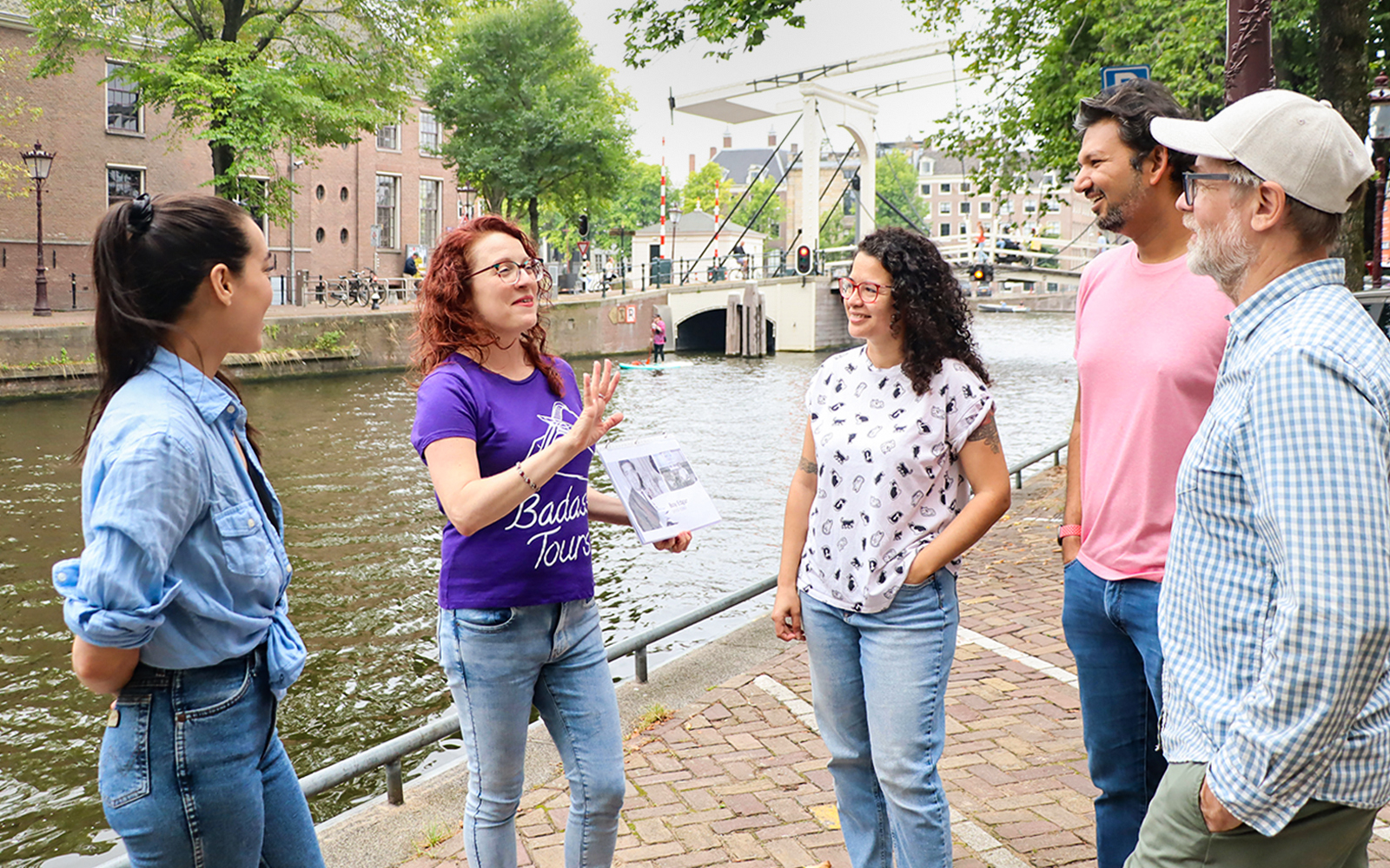 Tour guide with a group by a canal in Amsterdam on a Jewish history tour.