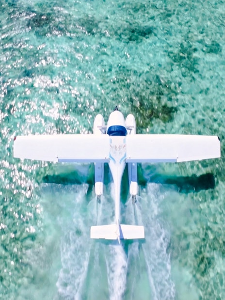 Seaplane flying over turquoise waters on Eastern Underwater Waterfall route, Mauritius.