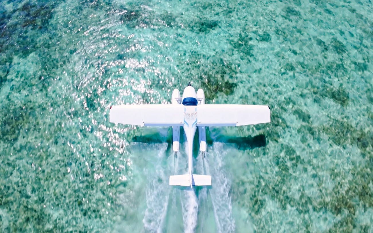 Seaplane flying over turquoise waters on Eastern Underwater Waterfall route, Mauritius.