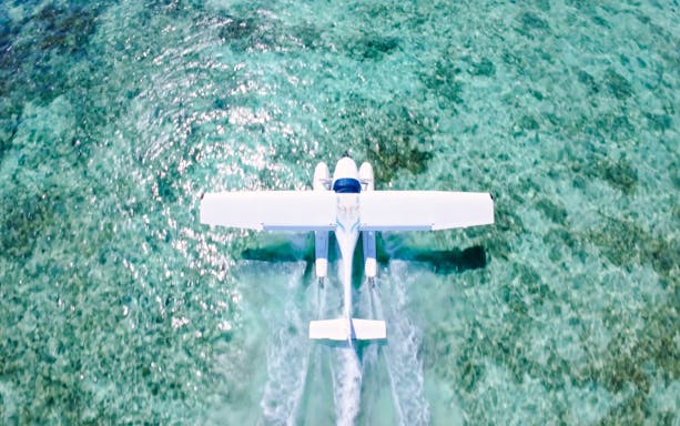 Seaplane flying over turquoise waters on Eastern Underwater Waterfall route, Mauritius.