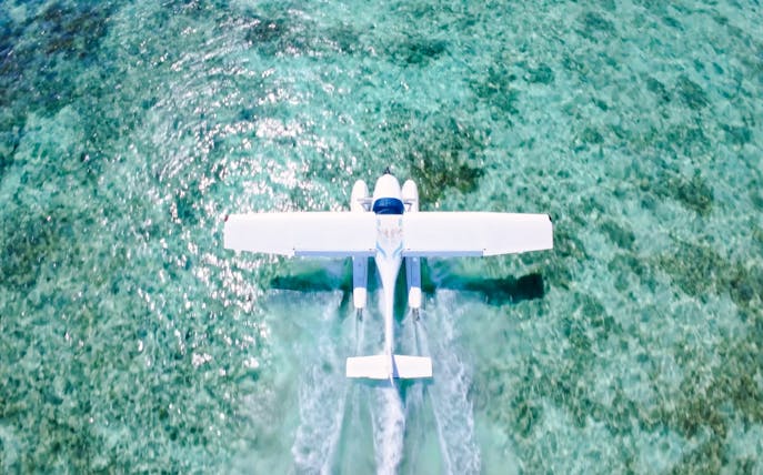 Seaplane flying over turquoise waters on Eastern Underwater Waterfall route, Mauritius.