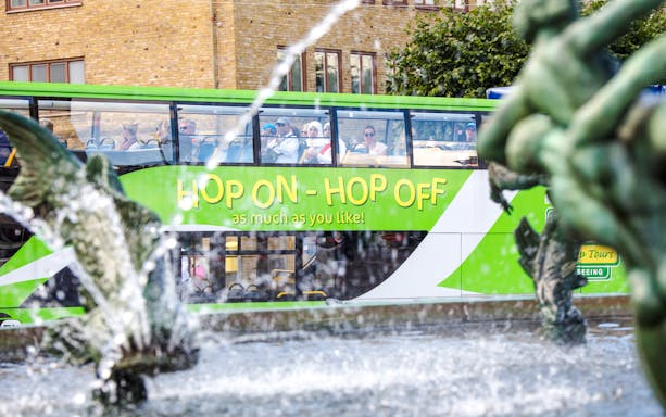 Hop on hop off bus at Götaplatsen square, Gothenburg with fountain in foreground.