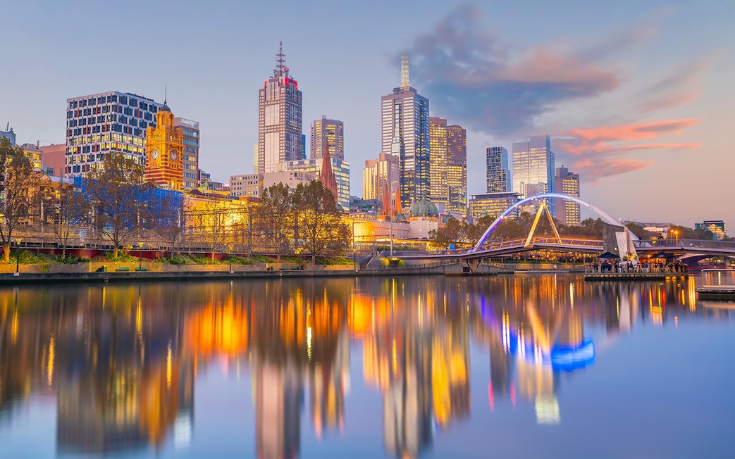Melbourne city skyline and Yarra River at sunset during river cruise.