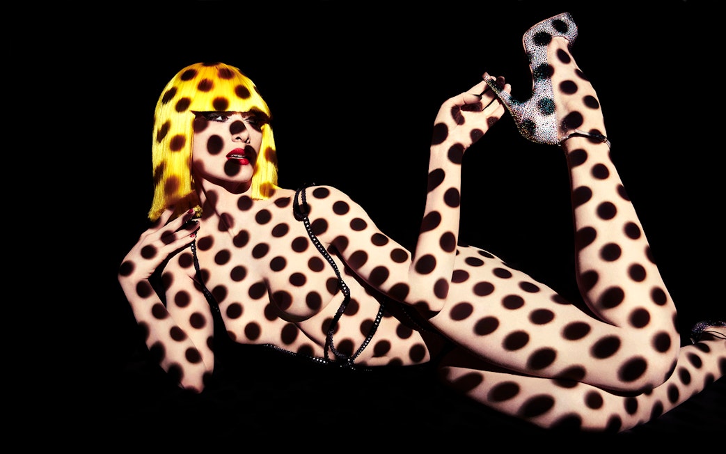 Performer with polka dot projection at Crazy Horse Show, Moulin Rouge, Paris.