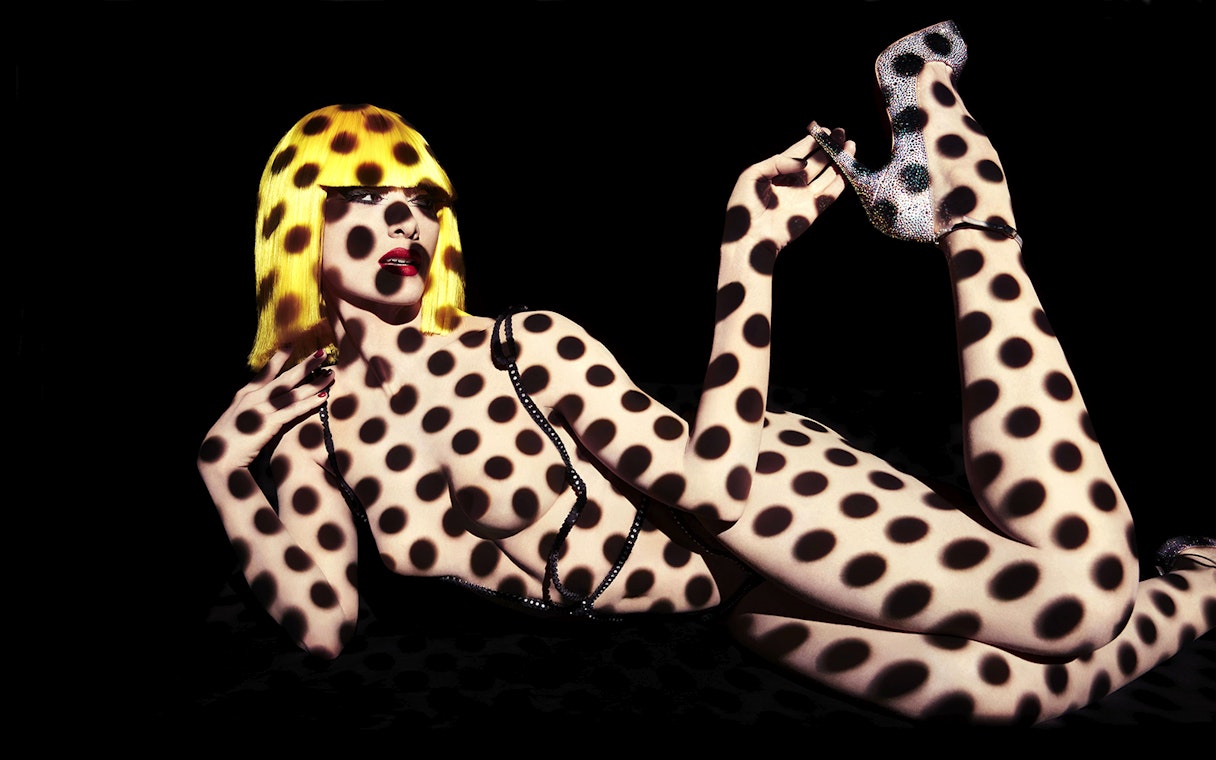 Performer with polka dot projection at Crazy Horse Show, Moulin Rouge, Paris.