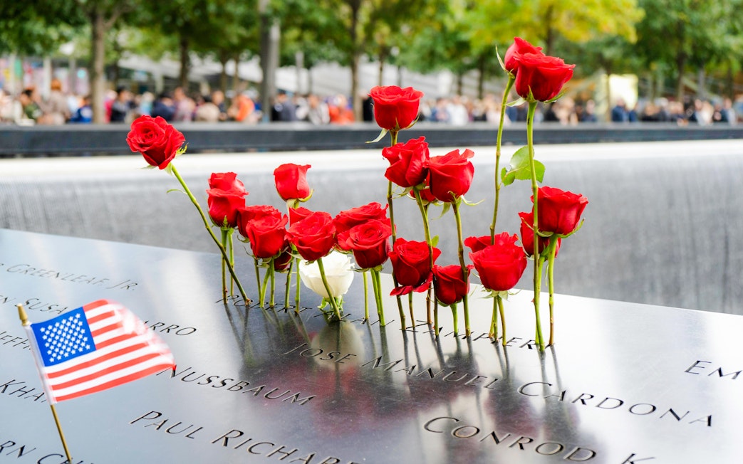 Red roses and an American flag at the National September 11 Memorial in New York City.