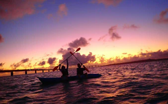 Paddlers at sunrise on Miyakojima stand-up paddleboard tour, Okinawa.