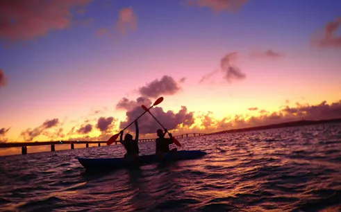 Paddlers at sunrise on Miyakojima stand-up paddleboard tour, Okinawa.
