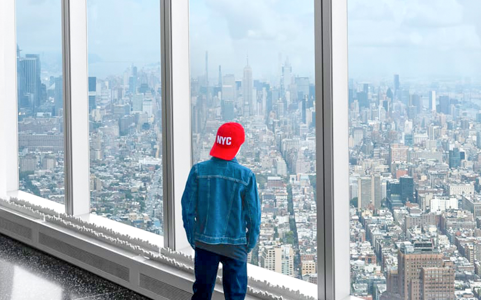Tourist viewing New York City skyline from One World Observatory.