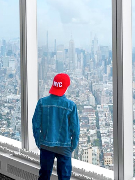 Tourist viewing New York City skyline from One World Observatory.