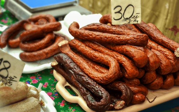 Kraków street market with traditional Polish sausages on display.
