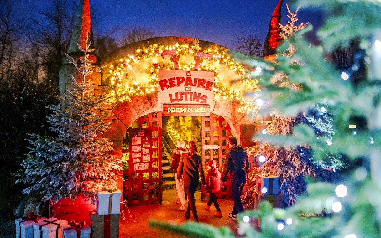 Visitors entering a festive elf-themed attraction at Parc Asterix during Christmas celebrations.