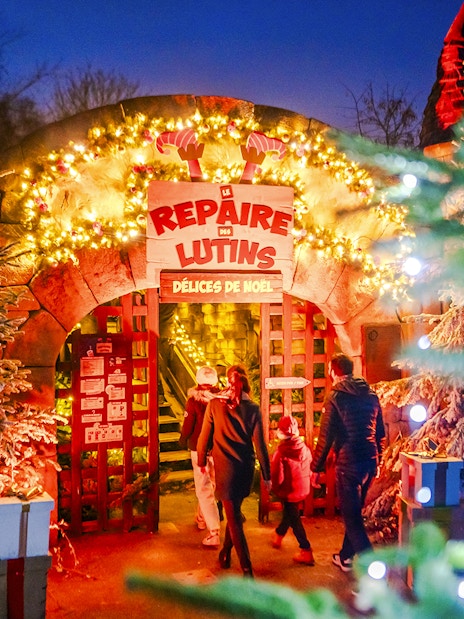 Visitors entering a festive elf-themed attraction at Parc Asterix during Christmas celebrations.