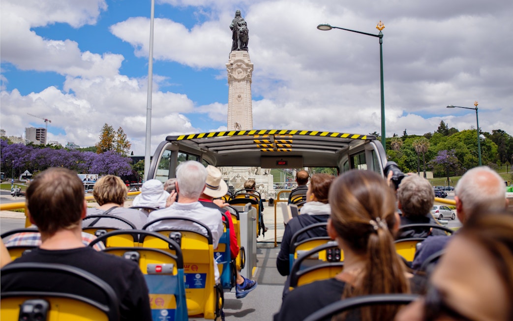 Tourists on a Yellow Bus passing the Marquis of Pombal Square in Lisbon.