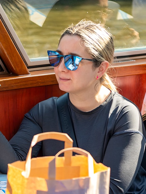 Person enjoying a drink on an Amsterdam canal cruise boat.