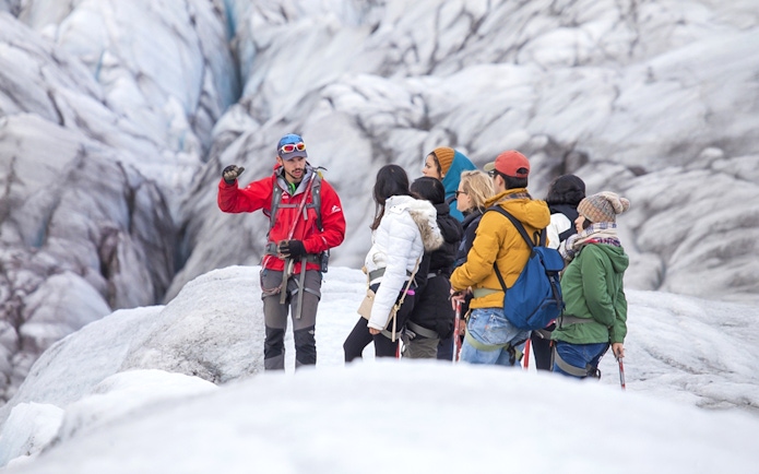 Tour guide explaining glacier features to group during Blue Ice Experience at Skaftafell.