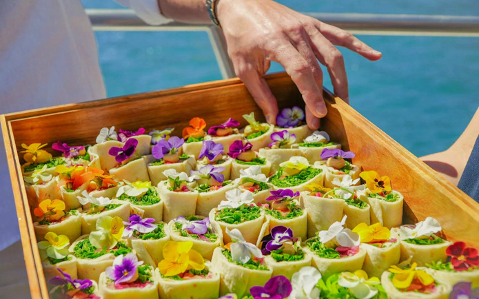 Brunch wraps with edible flowers on a tray near Benagil Caves.
