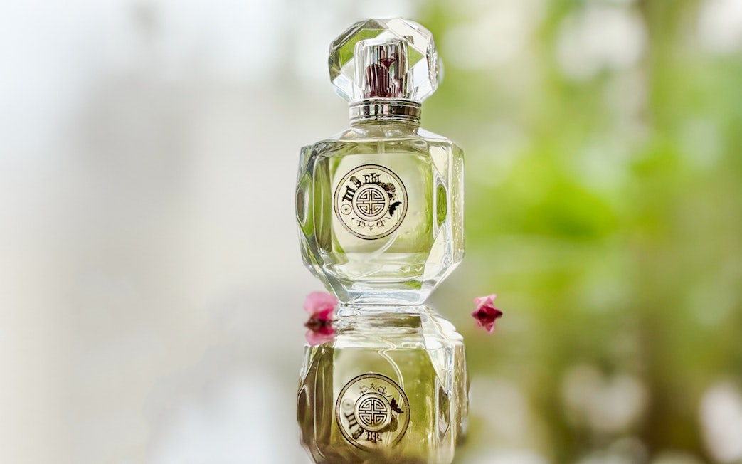 Premium perfume bottle Scentopia Sentosa Singapore with floral reflection.