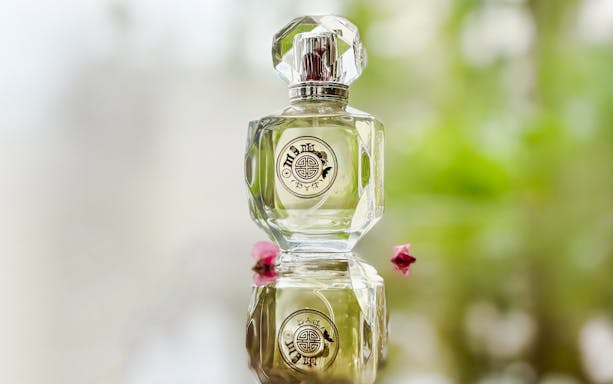 Premium perfume bottle Scentopia Sentosa Singapore with floral reflection.